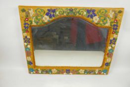 A shaped bevelled glass wall mirror in beadwork decorated frame, 18½" x 14½" overall