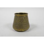 An Islamic brass pot with script decoration, 2½" high