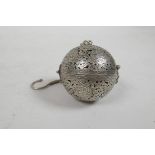 A pierced white metal ball incensor with Islamic decoration, opening to reveal a gimbal mounted