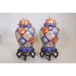 A pair of Oriental ceramic jars and covers, decorated with bright enamels in the Imari style, with