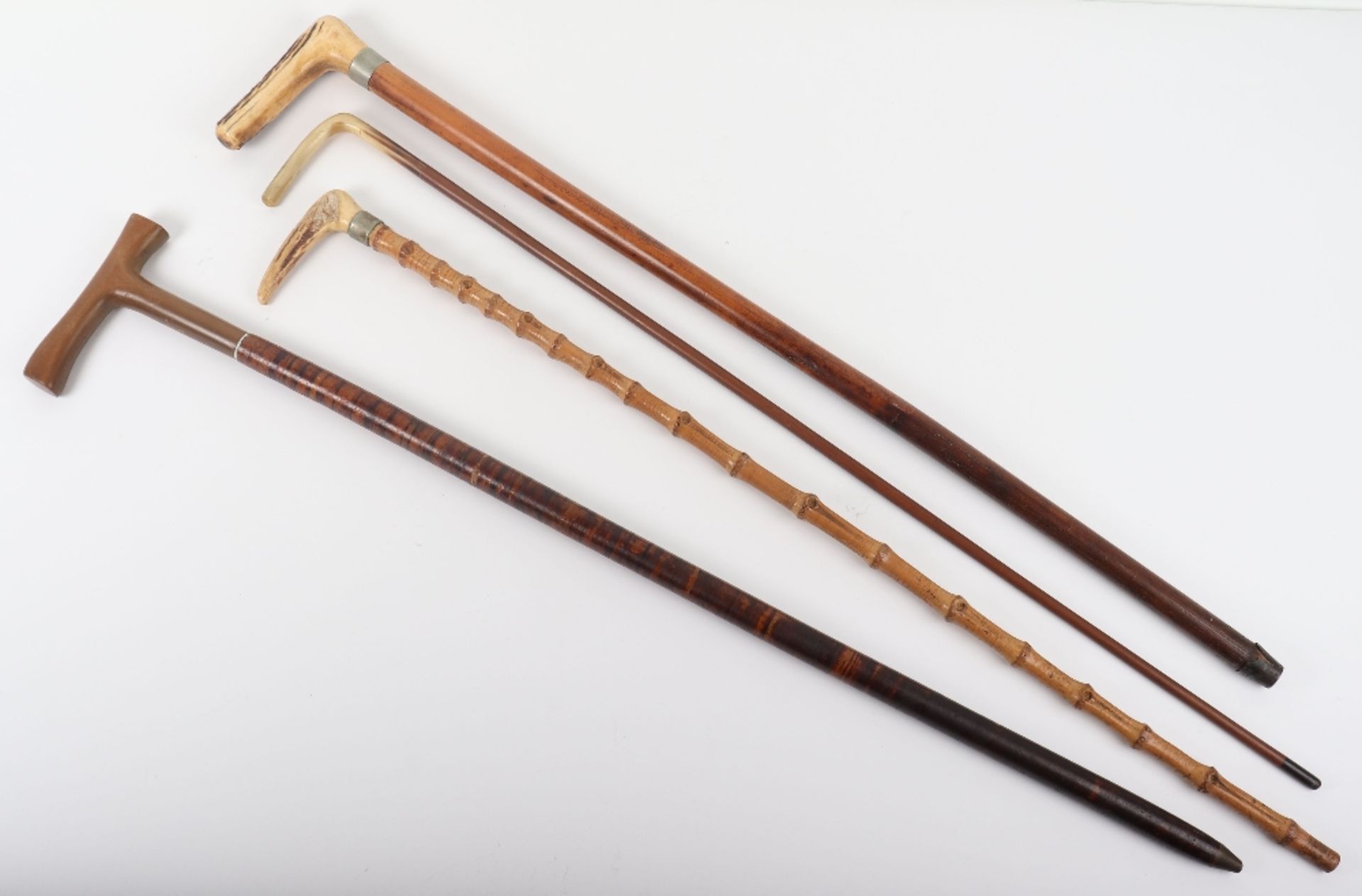 Two antler walking sticks, a horn handle stick and one other