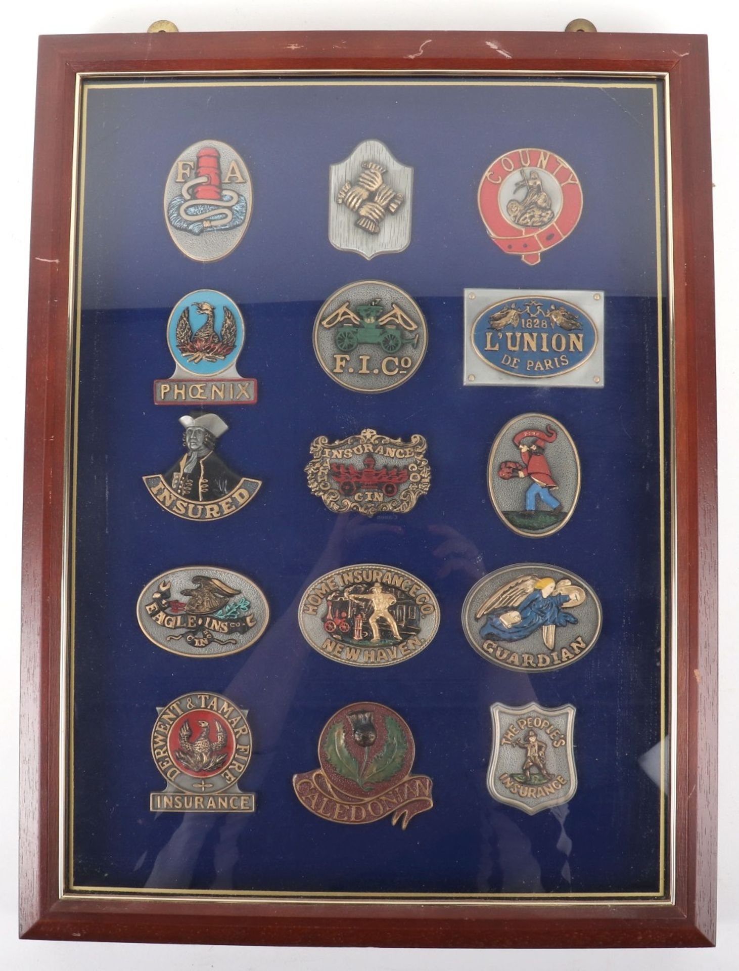 Fifteen Fine pewter fire insurance plaques, mounted in glass case