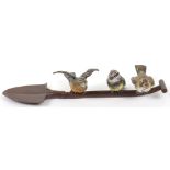 A 19th century cold painted bronze group of three birds sat atop a shovel, Austrian