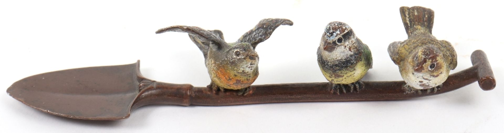 A 19th century cold painted bronze group of three birds sat atop a shovel, Austrian