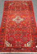 Persian hand knotted red ground wool rug, central medallion,