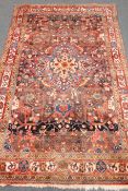 Persian style red ground rug, central medallion, repeating border,