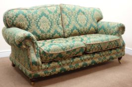 Traditional two seat sofa, scrolled arms, turned supports on brass castors,