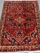 Chahal Mahal Vallyer hand knotted red ground wool rug, repeating border,
