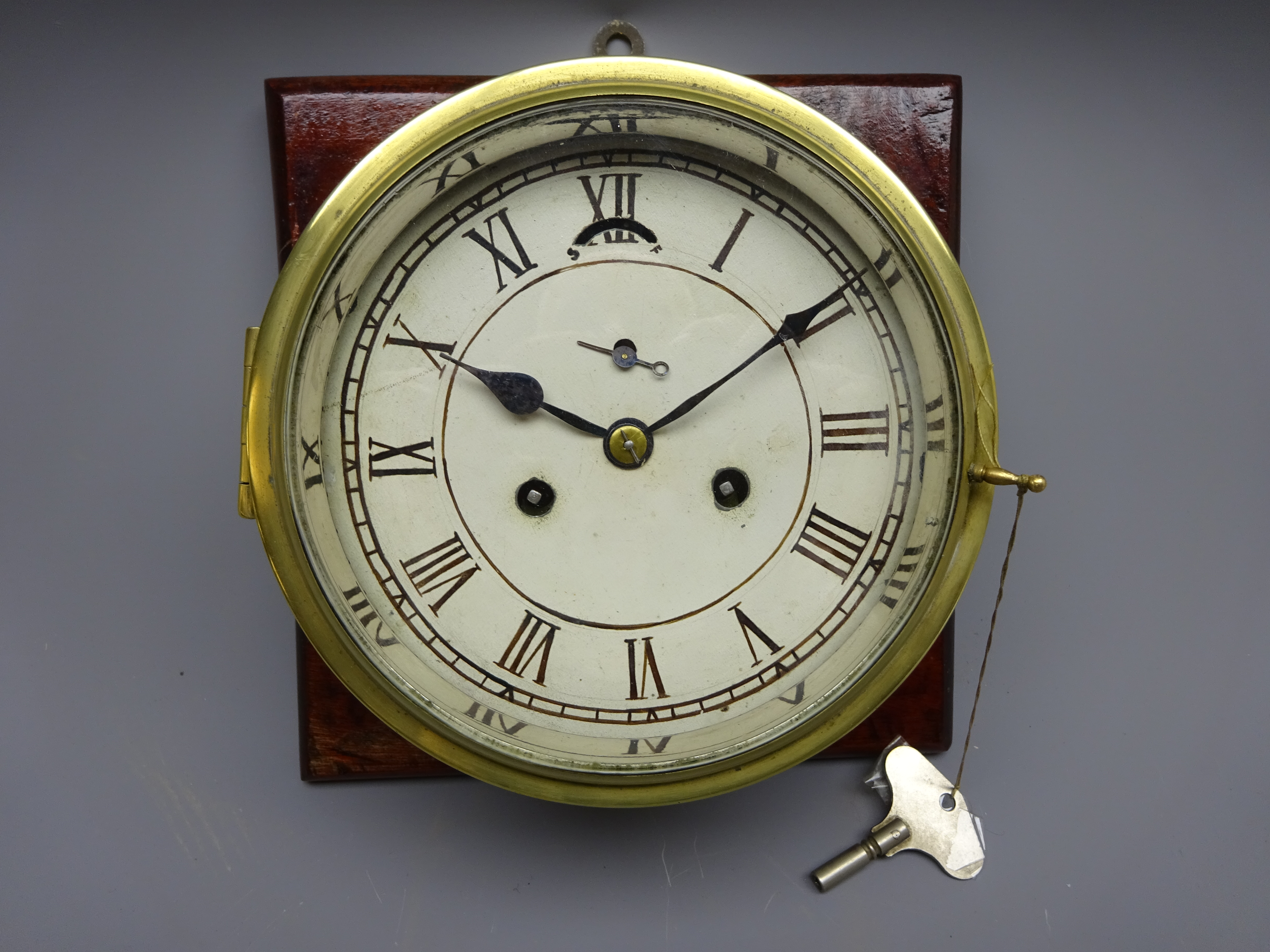Brass bulkhead clock, painted Roman dial with subsidiary seconds and twin train movement,