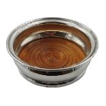 Silver wine coaster, with turned wooden base by C J Vander Ltd,
