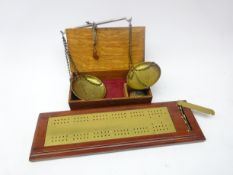 Cased set of portable brass scales with weights and brass mounted wooden cribbage board,