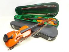 Two cased students violins with three bows