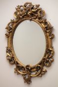 Gilt bevel edge oval cherub mirror, W60cm,