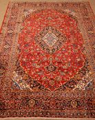 Kashan red ground rug, central medallion, floral field, repeating border,