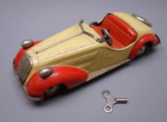 Distler clockwork tin-plate open top sports car in pale khaki with red wings and seats,