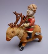 Early 20th century clockwork figure of Father Christmas with composition head and tin-plate body,