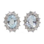 Pair of 18ct white gold oval aquamarine and round brilliant cut diamond cluster stud earrings,