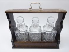 Oak three bottle 'tantalus' style decanter stand with silver-plated mounts and handle,
