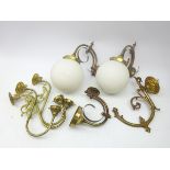 Three brass scroll wall lights, two with globular opaque glass shades,