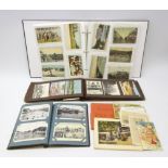 Three albums containing over four hundred and eighty Edwardian and later postcards including real