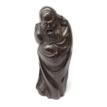 Chinese rosewood carving of an immortal, his robe incised with symbols and script,