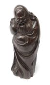 Chinese rosewood carving of an immortal, his robe incised with symbols and script,