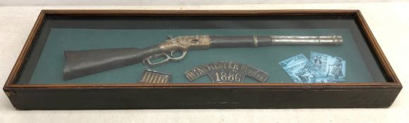Cased replica model of the Winchester Rifle in glazed display case, L106cm, H33cm,