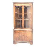 Reprodux Bevan Funnell mahogany concave corner display cabinet, projecting cornice, dentil frieze,