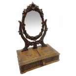 Black Forest carved toilet mirror, the swing mirror with foliate surround,