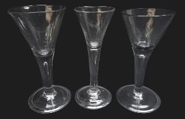 Three wine glasses each with trumpet bowl rising from a thick plain stem enclosing a single tear on