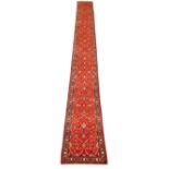 Kashan red ground runner, palmette floral scroll filled muticoloured field within repeating border,