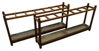 Pair Edwardian country house oak stick stands, each with seven compartments and two drip trays,