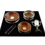 Three silver wine coasters with turned wooden base by W I Broadway & Co and WEV,