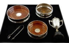 Three silver wine coasters with turned wooden base by W I Broadway & Co and WEV,