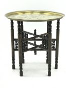 Early 20th century circular brass table top on Moorish style folding stand, D58cm,