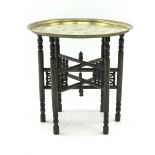 Early 20th century circular brass table top on Moorish style folding stand, D58cm,