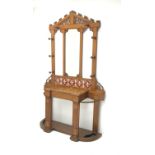 Late Victorian oak hall stand, raised tiled back with shaped and pierced pediment,