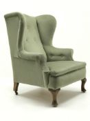Early 20th century Queen Anne style wing back upholstered in a lime fabric,