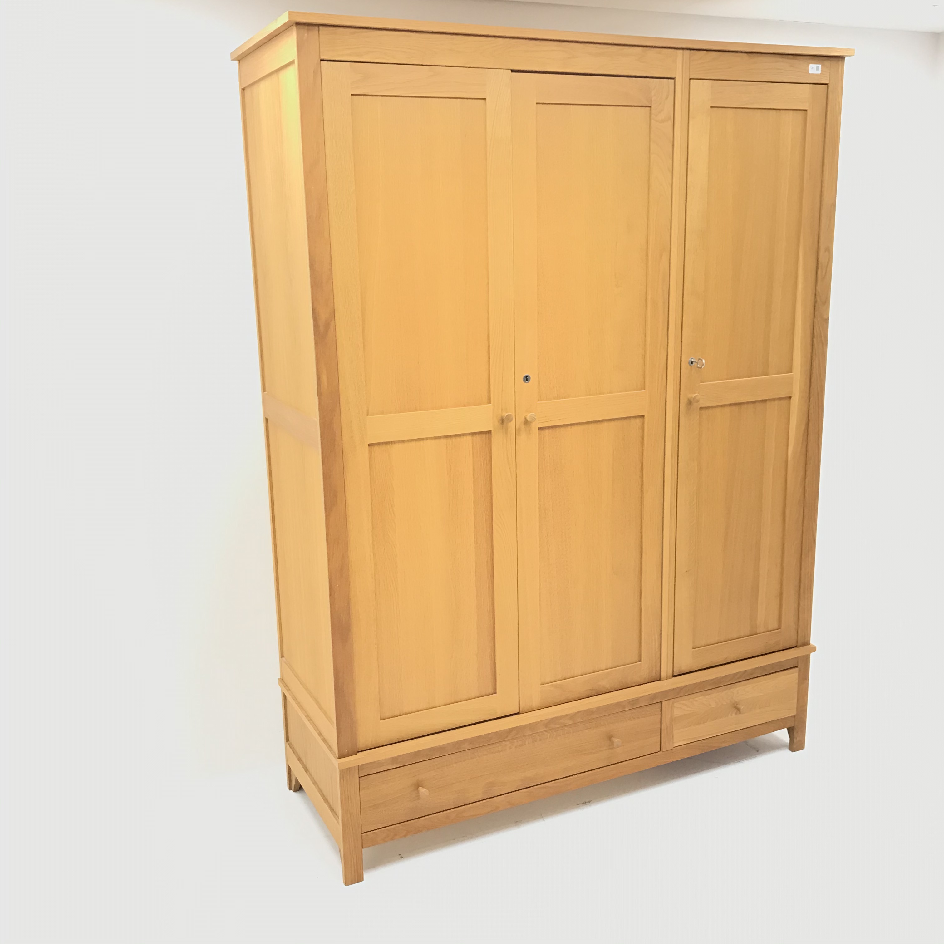 Light oak triple combination wardrobe, three doors above one long and one short drawer,