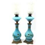 Pair of early 20th century blue opaque glass oil lamps,