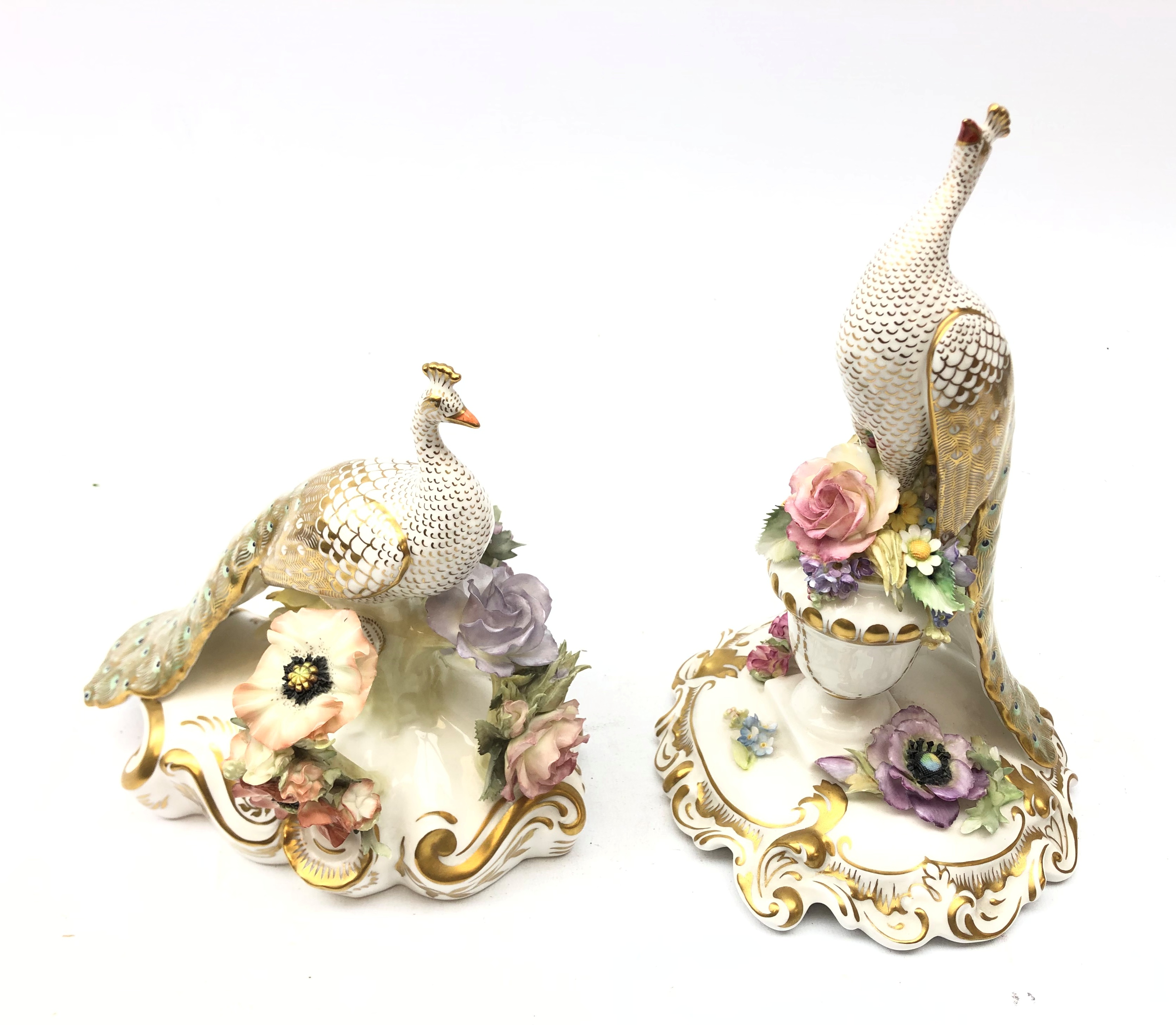 Royal Crown Derby model of a peacock atop a floral encrusted urn, signed C.Till & J.