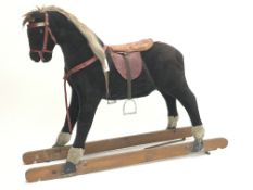 Early 20th century plush covered rocking horse, saddle and stirrups, no trestle base,