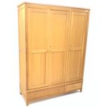 Light oak triple combination wardrobe, three doors above one long and one short drawer,