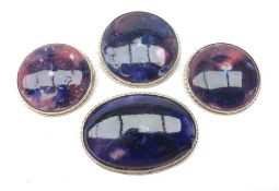 Three Moorcroft Pansy pattern circular brooches and an oval example in silver-plated mounts,