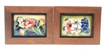 Two Moorcroft framed rectangular box lids decorated with floral sprays,