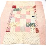 Victorian patchwork quilt, using printed cottons in pinks, purples, reds,