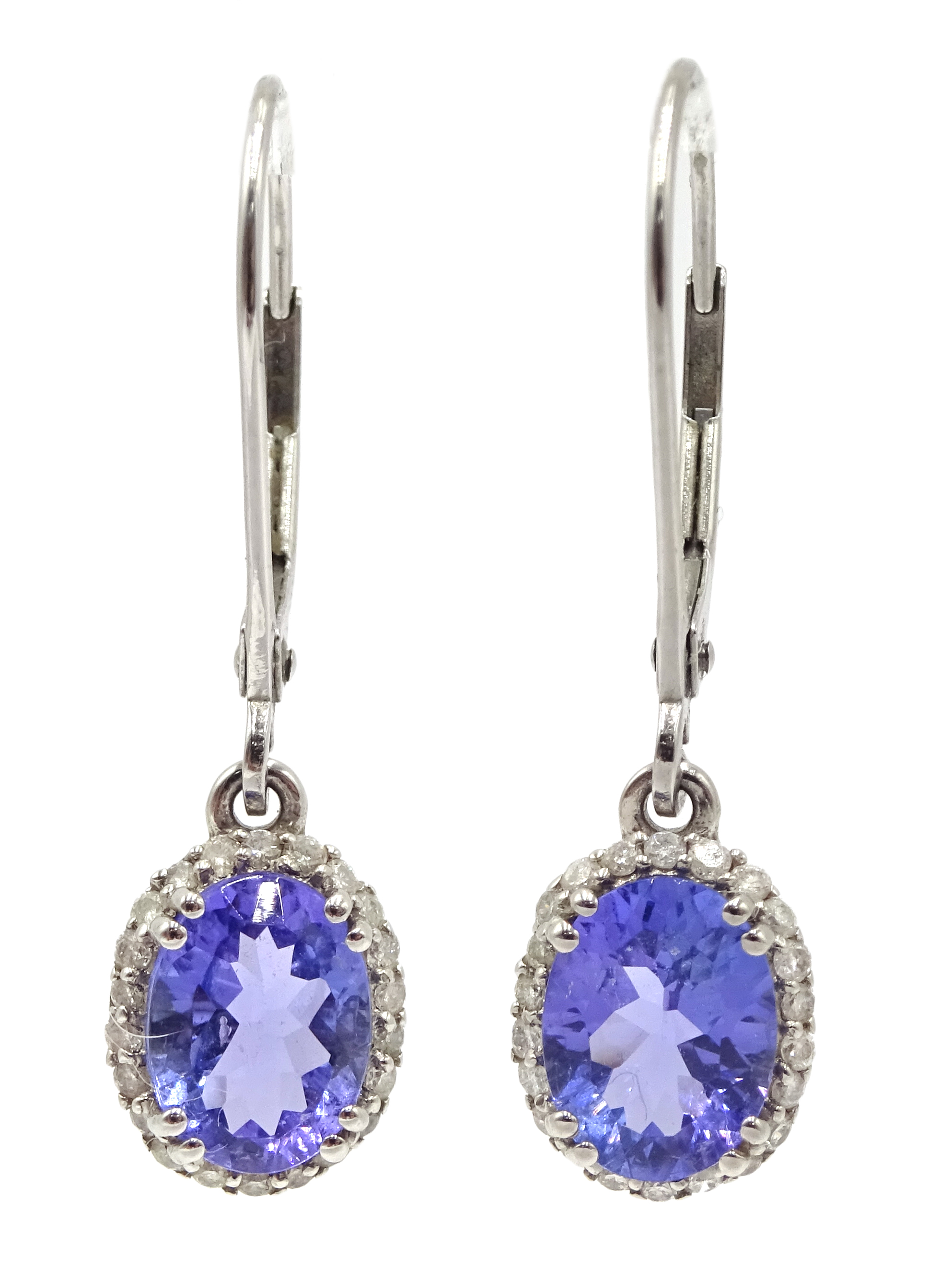 Pair of platinum oval tanzanite and diamond cluster pendant earrings,