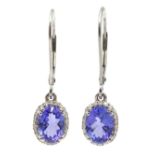 Pair of platinum oval tanzanite and diamond cluster pendant earrings,
