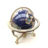 Polished stone inlaid terrestrial globe on brass finish stand,