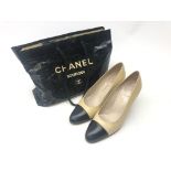 Pair of Chanel cream and black leather heeled court shoes size 39 1/2 with carrier bag